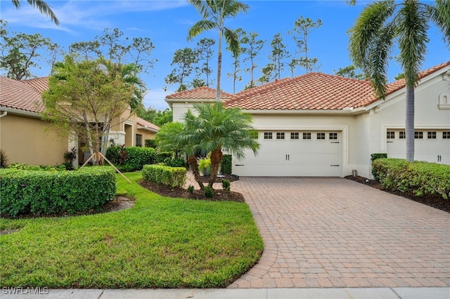 mediterranean / spanish-style home with a garage and a front yard