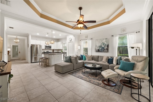 tiled living room featuring ceiling fan, a raised ceiling, and ornamental molding