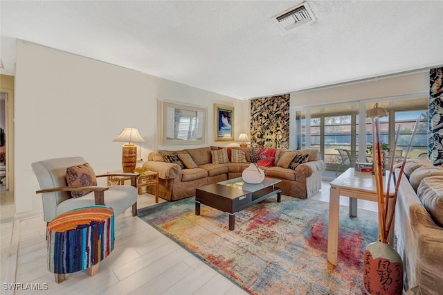 living room with light wood-type flooring and a textured ceiling