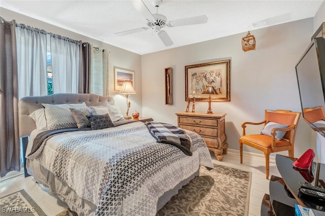 bedroom featuring a textured ceiling, ceiling fan, and light hardwood / wood-style flooring