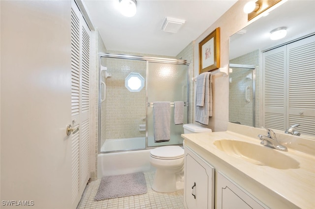 full bathroom featuring combined bath / shower with glass door, tile patterned floors, vanity, and toilet