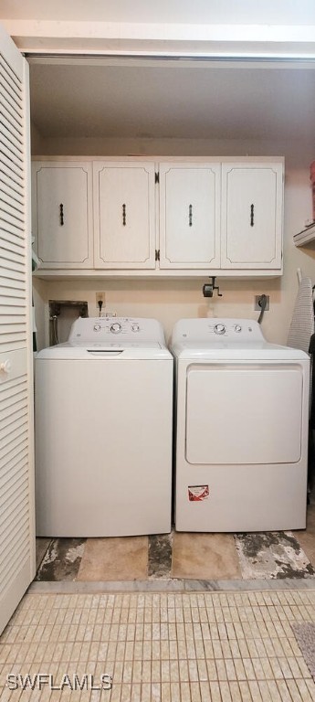 washroom with washer and clothes dryer and cabinets