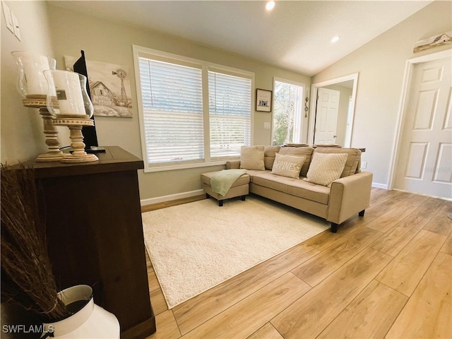 living room with light hardwood / wood-style floors and lofted ceiling