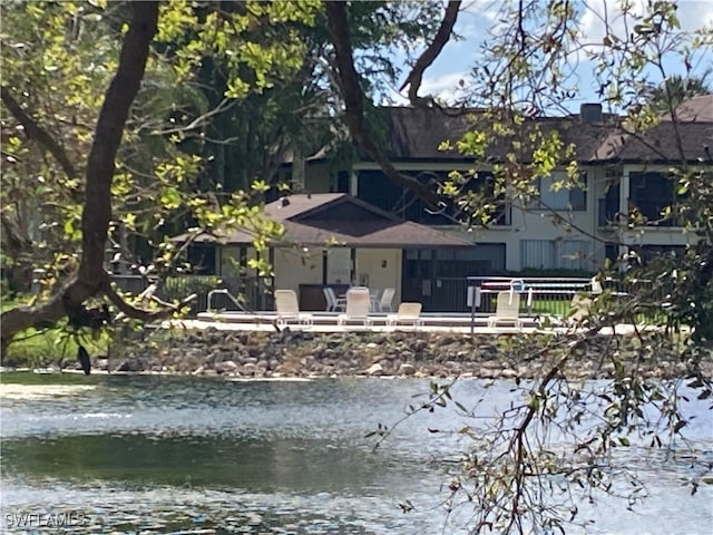 rear view of property featuring a water view and a patio