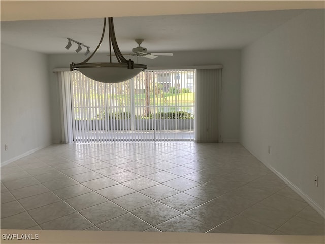 tiled spare room featuring ceiling fan