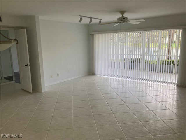 tiled empty room with ceiling fan and rail lighting