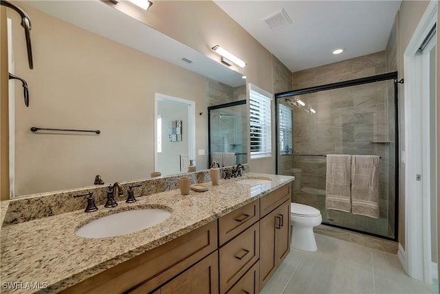 bathroom featuring toilet, visible vents, a sink, and tile patterned floors