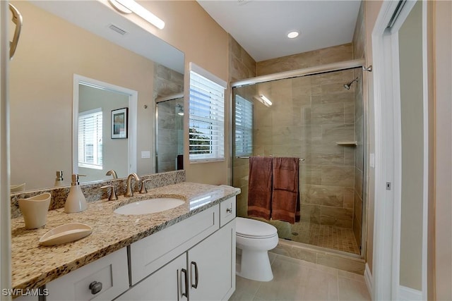 full bathroom featuring toilet, a sink, visible vents, a shower stall, and double vanity