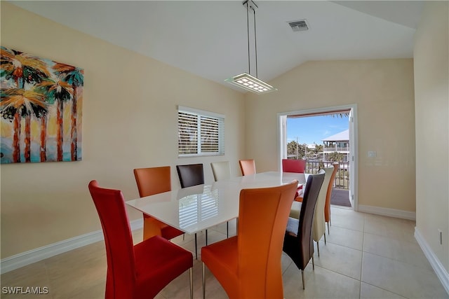 dining space featuring light tile patterned floors, baseboards, visible vents, and vaulted ceiling