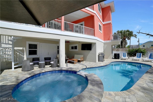 view of swimming pool with grilling area, a patio area, and a pool with connected hot tub