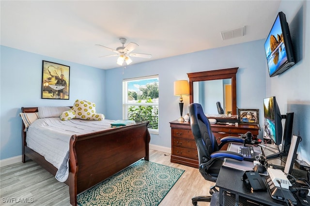 bedroom featuring baseboards, ceiling fan, visible vents, and light wood-style floors