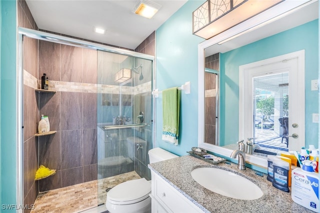 bathroom featuring a stall shower, vanity, and toilet