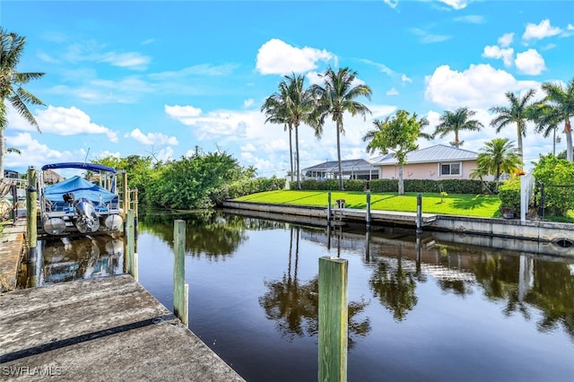 view of dock with a water view, a lawn, and boat lift