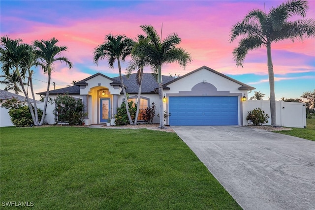 ranch-style house featuring an attached garage, fence, concrete driveway, stucco siding, and a front yard