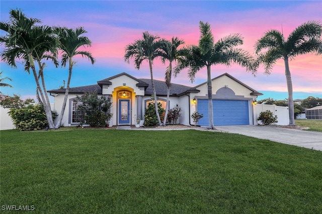 view of front of home with a garage, a lawn, concrete driveway, fence, and stucco siding