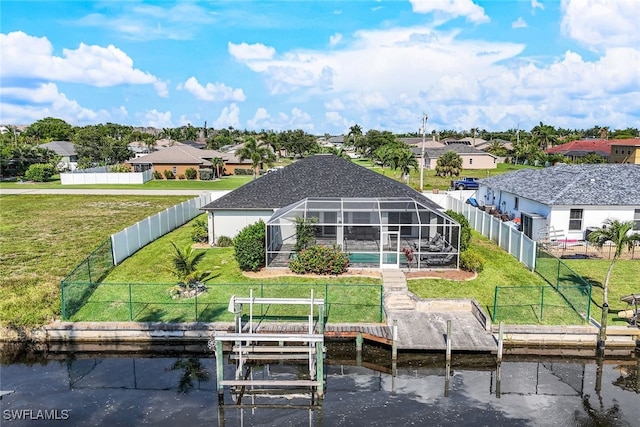 back of house with a residential view, a lanai, a fenced backyard, and boat lift