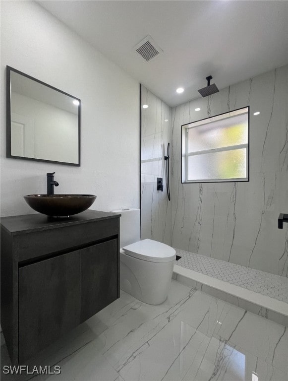 bathroom featuring toilet, vanity, and tiled shower