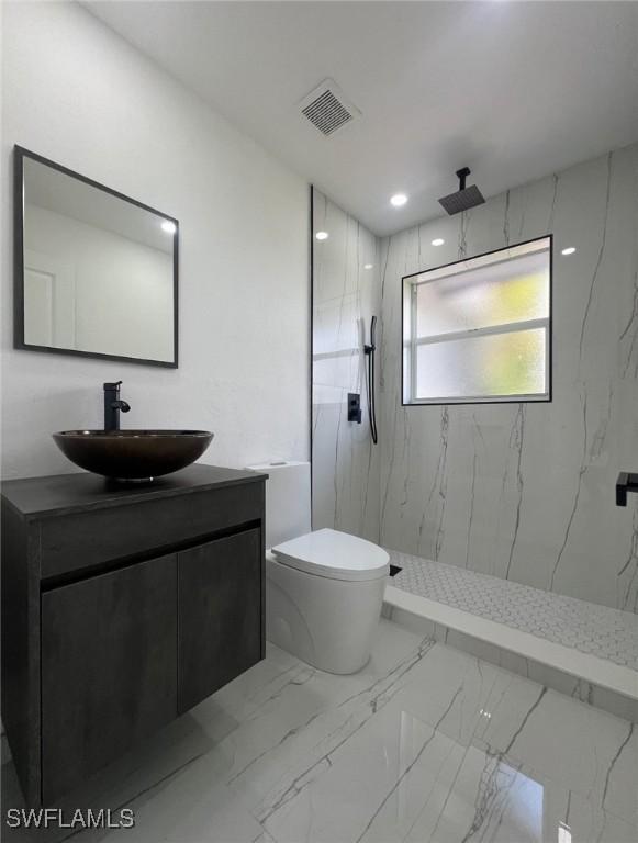 4562 Tennyson Dr, North Fort Myers, FL 33903 - full bathroom with marble finish floors, vanity, and a marble finish shower