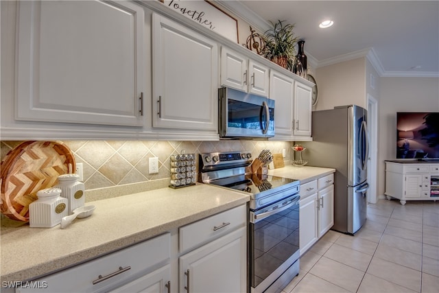 kitchen with white cabinets, light tile patterned floors, tasteful backsplash, crown molding, and appliances with stainless steel finishes