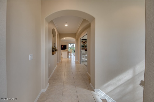 corridor with light tile patterned floors and ornamental molding