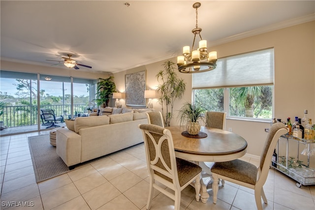 dining area featuring ornamental molding, light tile patterned flooring, and ceiling fan with notable chandelier