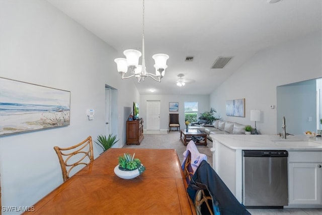 carpeted dining area with sink, vaulted ceiling, and ceiling fan with notable chandelier