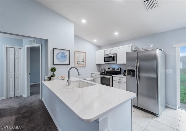 kitchen with appliances with stainless steel finishes, sink, vaulted ceiling, white cabinets, and kitchen peninsula