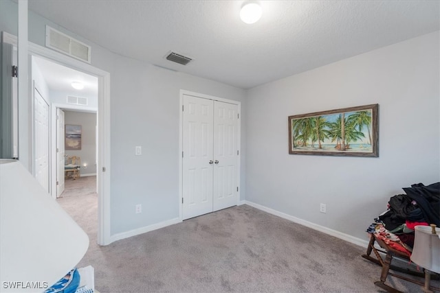 unfurnished bedroom with light colored carpet and a closet