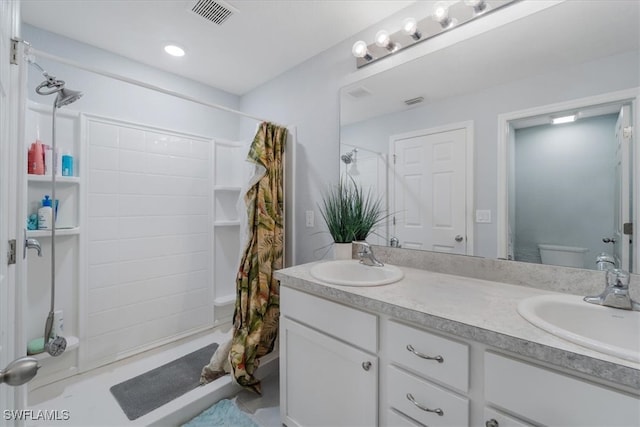 bathroom with curtained shower, vanity, and toilet