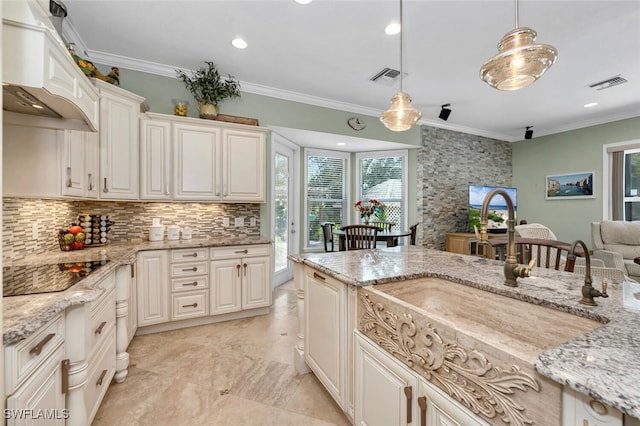 kitchen with light stone counters, black electric stovetop, decorative light fixtures, and custom exhaust hood