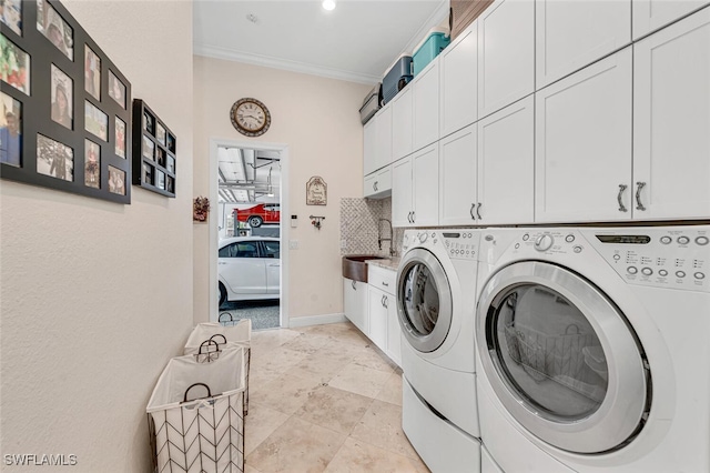 washroom featuring cabinets, washer and clothes dryer, and ornamental molding