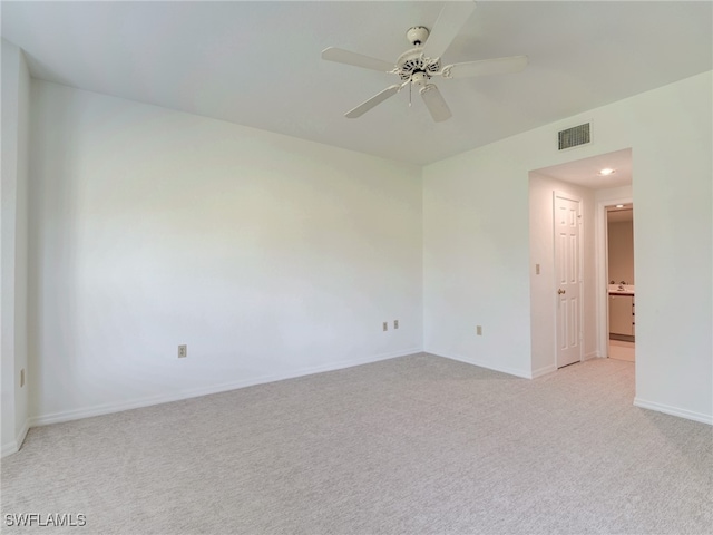 spare room with baseboards, ceiling fan, visible vents, and light colored carpet