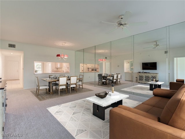 living room with visible vents, ceiling fan, and light carpet