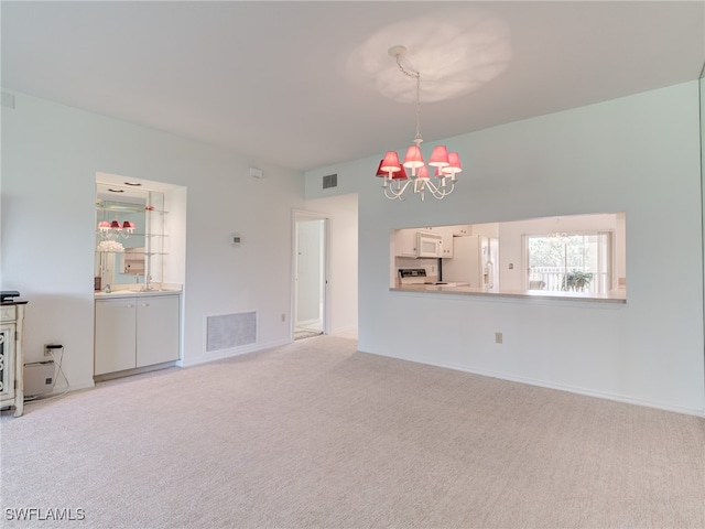 unfurnished living room with a chandelier, visible vents, and light carpet