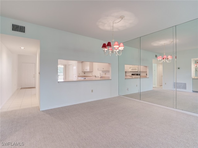 interior space featuring light tile patterned flooring, light colored carpet, visible vents, and an inviting chandelier