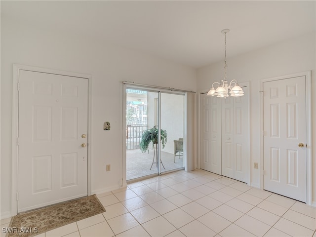 foyer entrance featuring light tile patterned floors and a notable chandelier