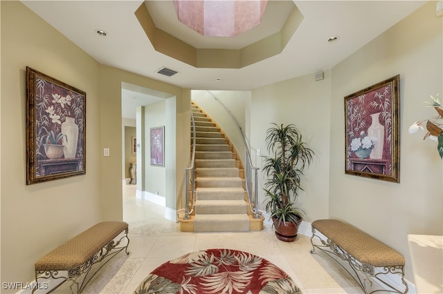 interior space featuring tile patterned flooring and a tray ceiling