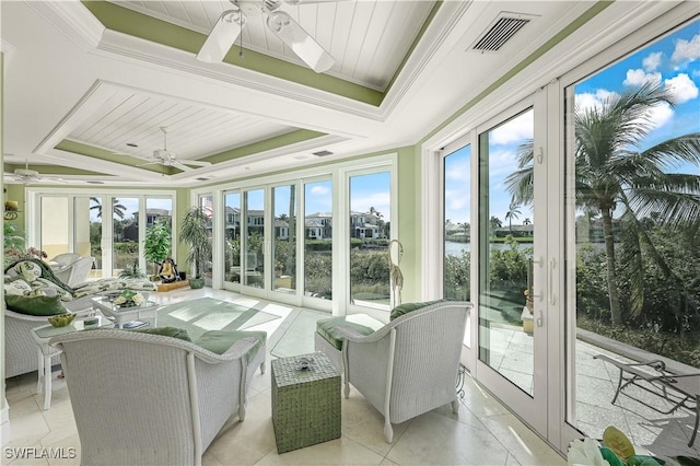 sunroom featuring a raised ceiling and ceiling fan