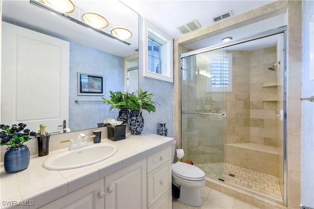 bathroom featuring toilet, tile patterned floors, walk in shower, and vanity