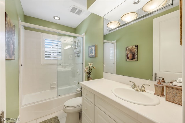 full bathroom featuring tile patterned flooring, shower / bath combination with glass door, vanity, and toilet