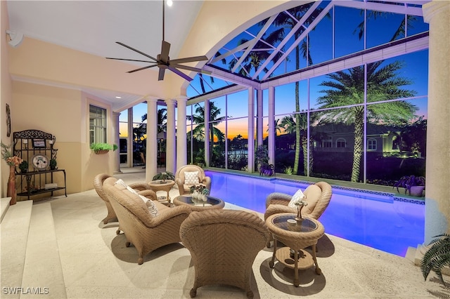 pool at dusk featuring ceiling fan