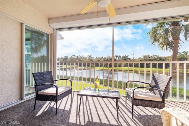 sunroom / solarium with ceiling fan and a water view