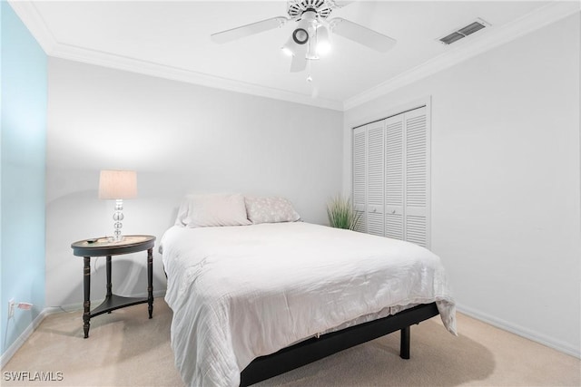 carpeted bedroom with ceiling fan, a closet, and ornamental molding