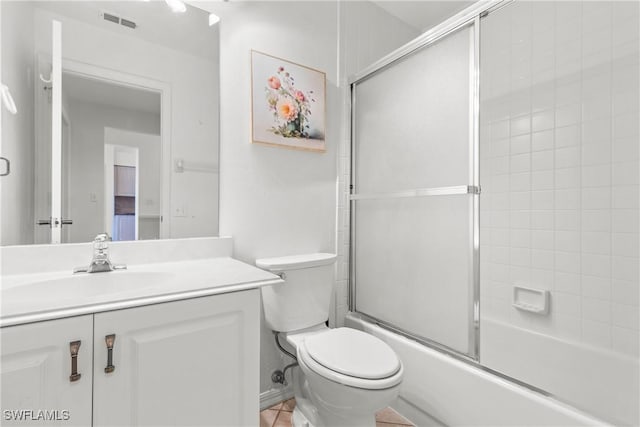 full bathroom featuring vanity, enclosed tub / shower combo, and toilet