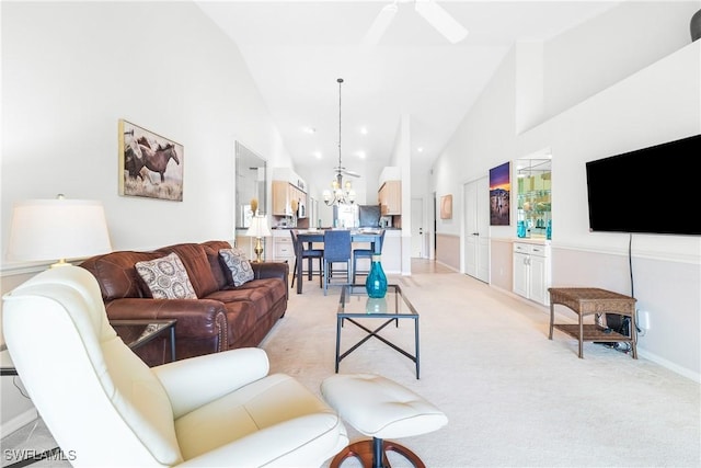 living room with light carpet, ceiling fan with notable chandelier, and high vaulted ceiling