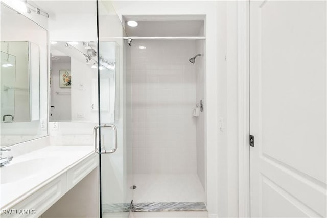 bathroom featuring vanity and a shower with shower door