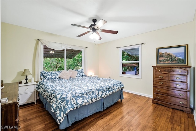 bedroom with multiple windows, dark hardwood / wood-style flooring, and ceiling fan