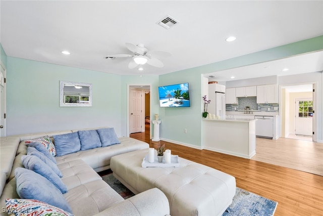 living room featuring light hardwood / wood-style floors and ceiling fan