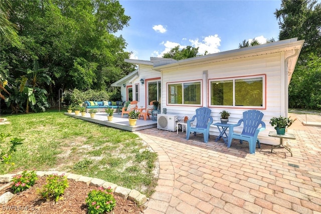 rear view of house featuring a yard, a patio, and an outdoor hangout area