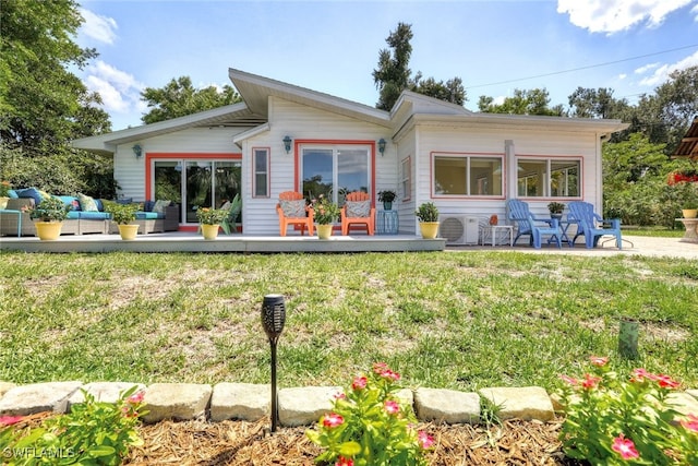 rear view of house featuring a lawn